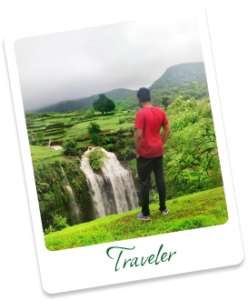 Traveler standing near a green waterfall trek